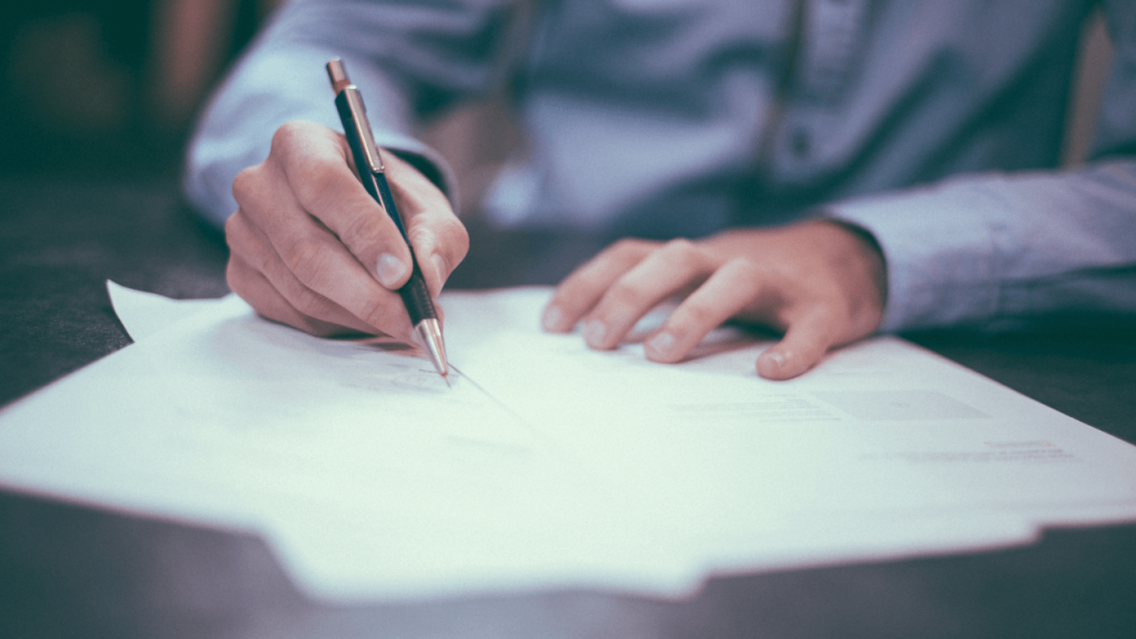 Person writing on documents